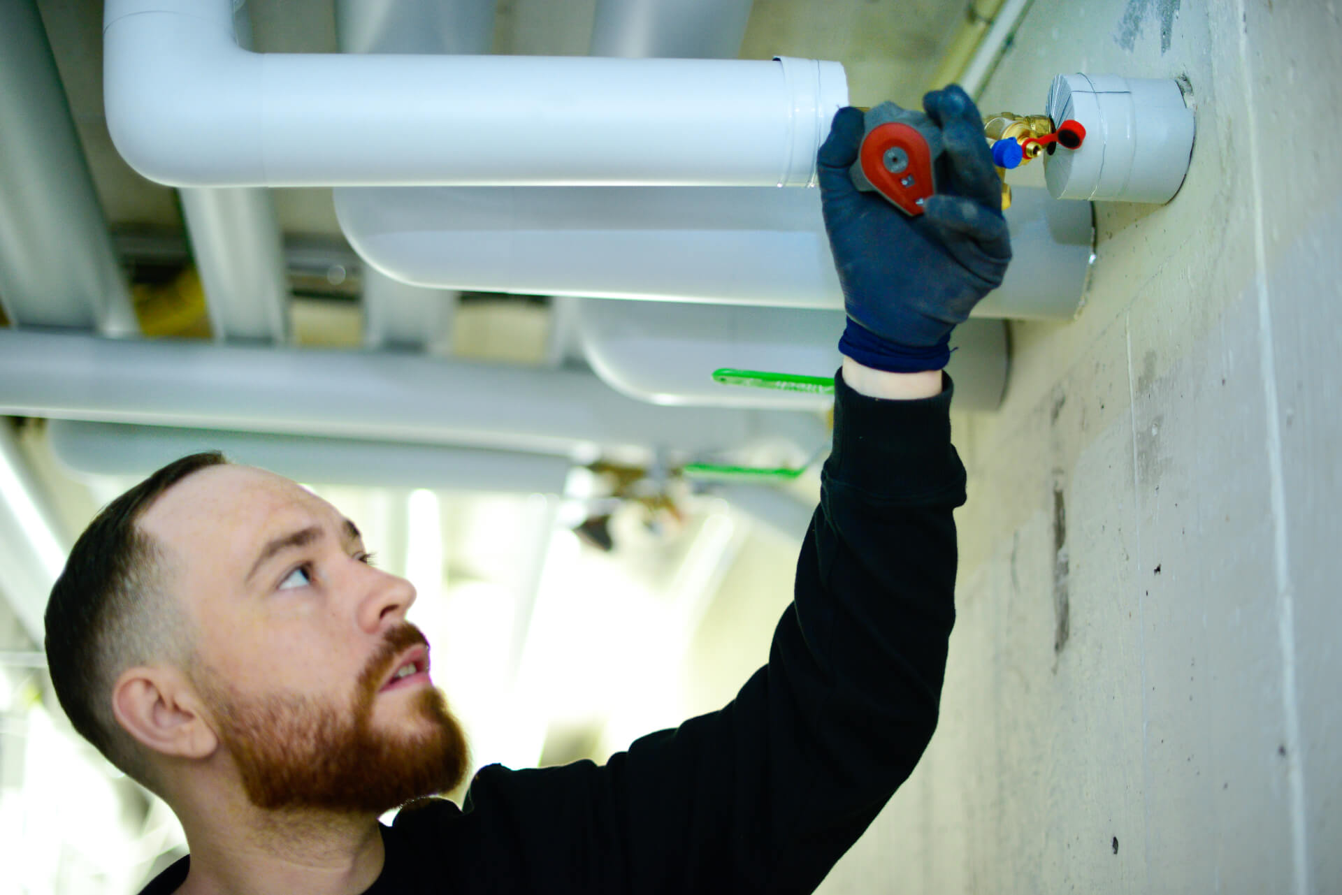 Montör från Jörgensens Rör installerar nya rör i taket